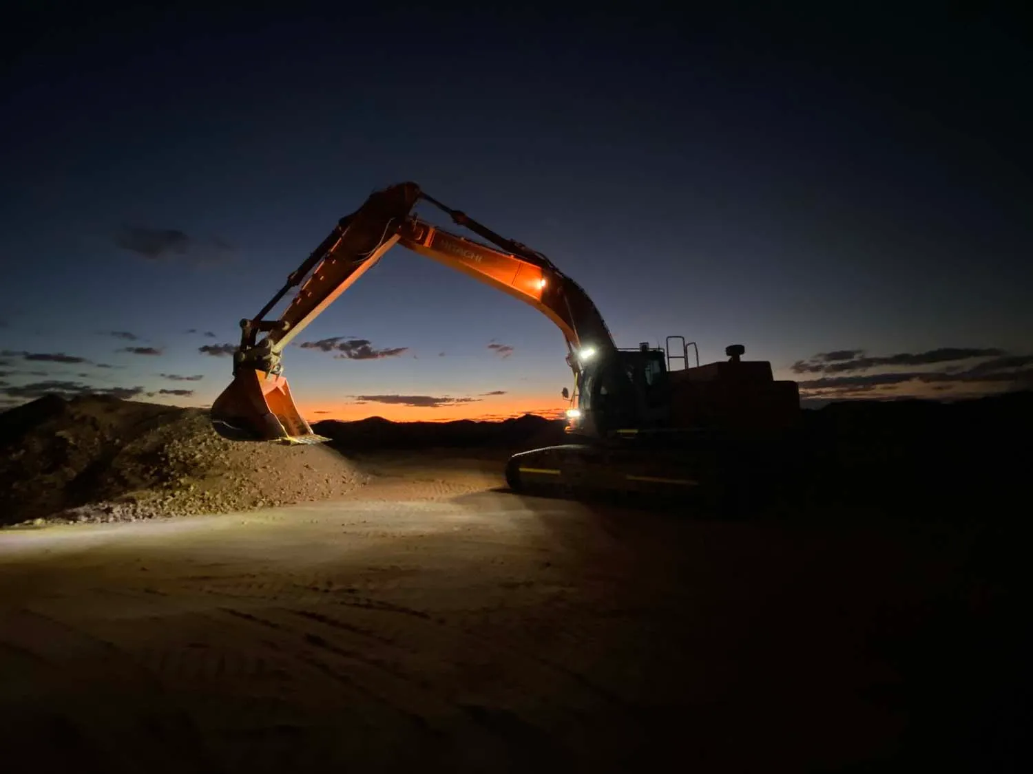 An excavator prepared for night mining at sunset in Coober Pedy