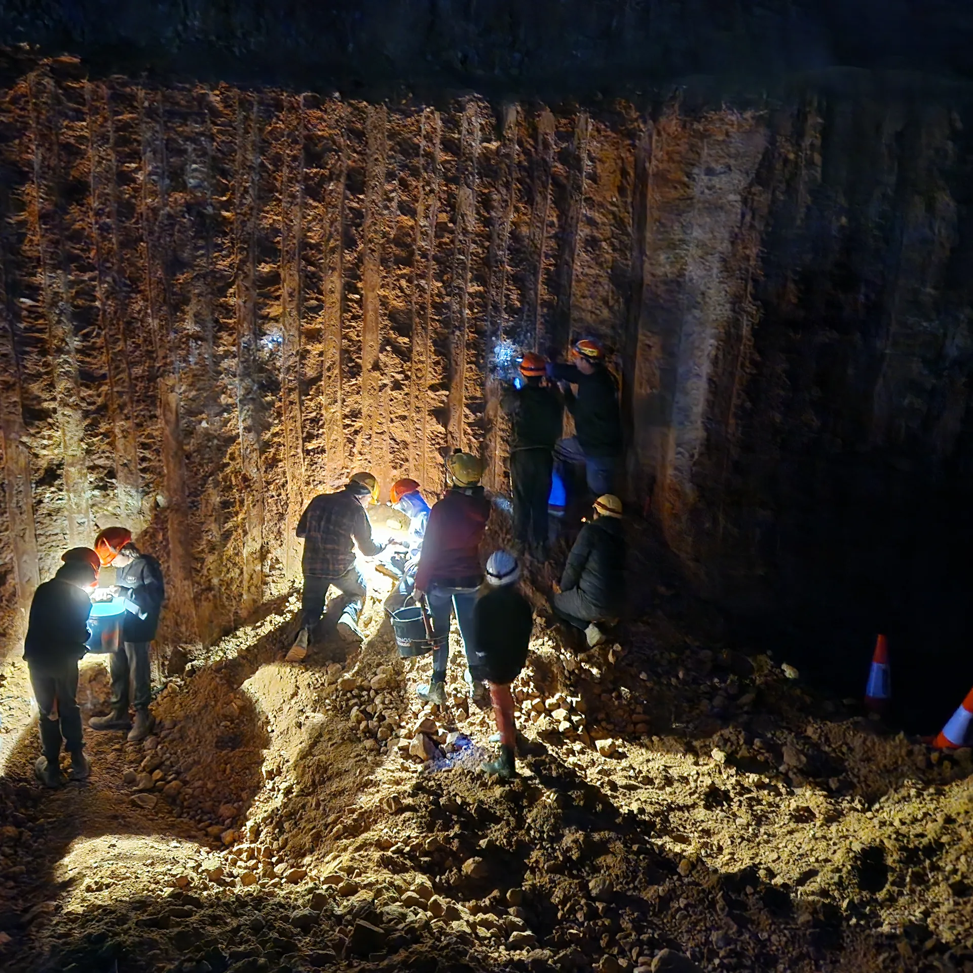 Guests searching for opal with lights on Dan's mine face